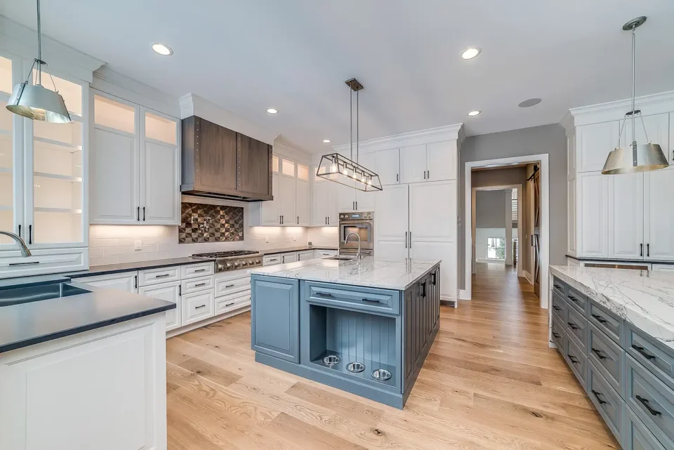 modern kitchen with wood flooring and white and blue cabinets